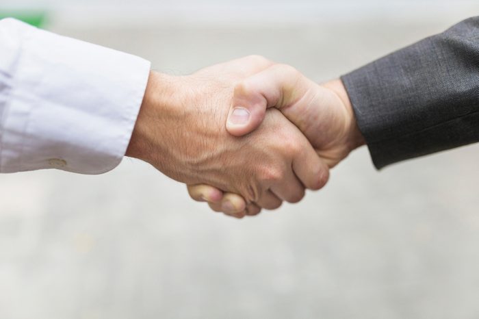 Closeup of two confident business man shaking hands