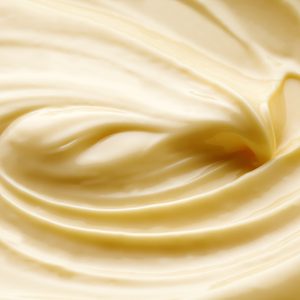 Creamy mixture swirls smoothly, creating a textured pattern in a close-up view.