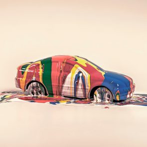 Car melting into colorful puddles, blending vibrant shades, on a neutral background.