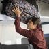 The Real Reason Why a Flight Attendant Won't Lift Your Bag into the Overhead Bin