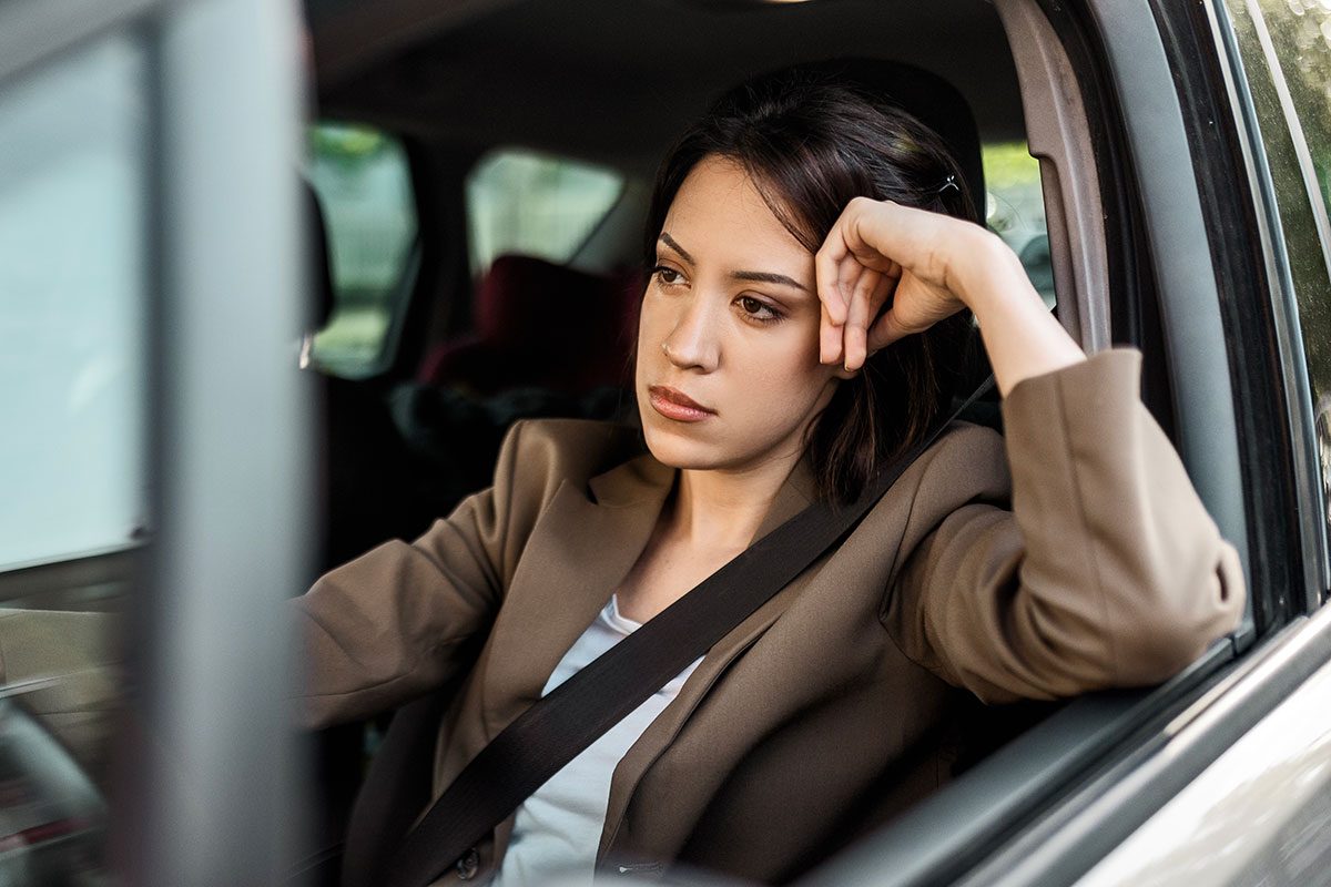 Young businesswoman driving a car feeling frustrated