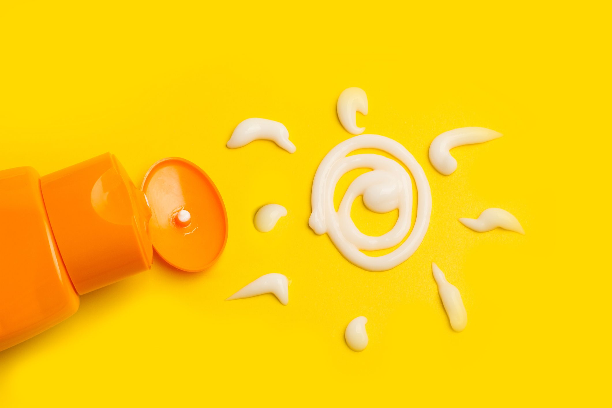 A sun cream protection bottle with a sun drawed with cream