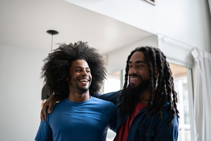 Happy brothers embracing at home