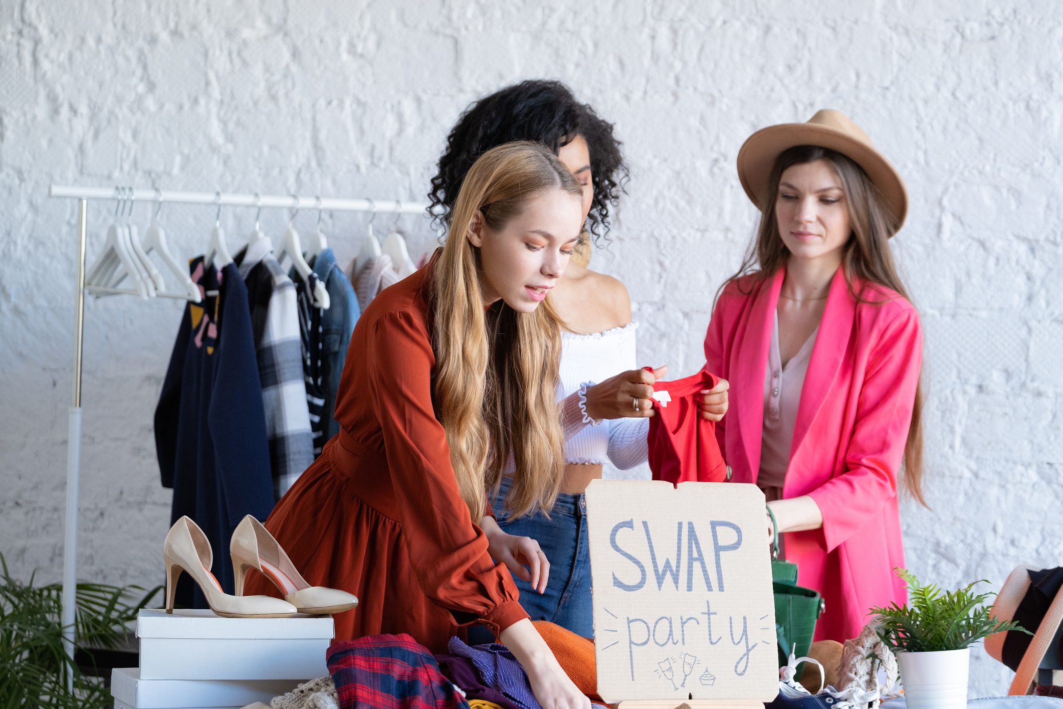 Happy young women at swap party. Zero waste shopping, reduce and reuse, donation