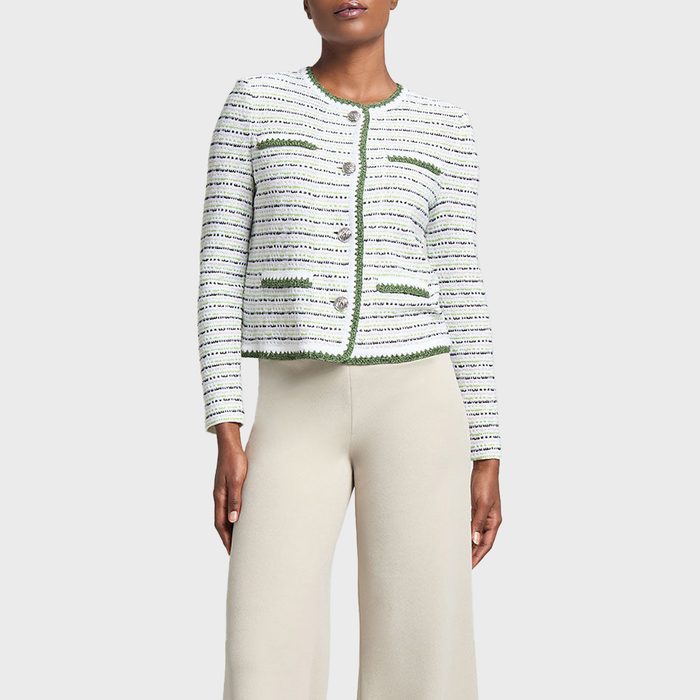 A woman with short hair wears a Ming Wang Stripe Knit Jacket in a Heritage Fit, featuring white and green horizontal stripes, paired with cream-colored pants